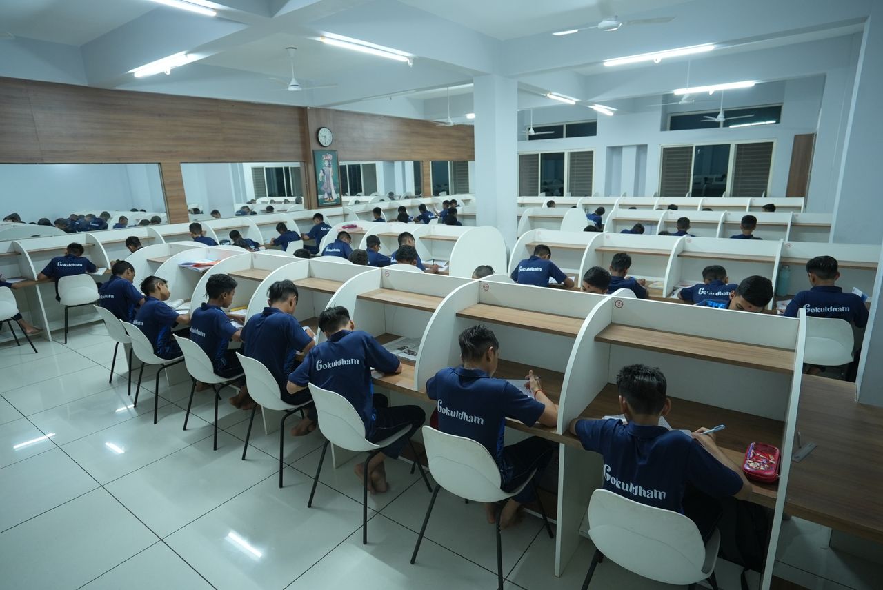Careers Students studying in a modern library at Petlad. Focused educational setting fostering learning.